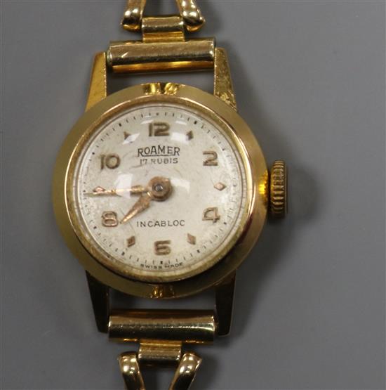 A ladys 18ct gold Roamer manual wind wrist watch, on a 9ct gold bracelet.